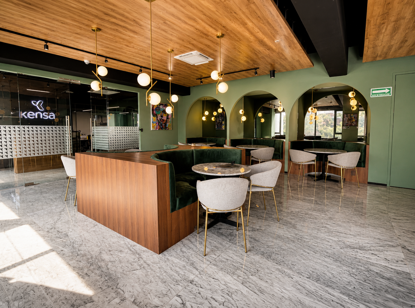 Área lounge de Colony con arcos verdes, mármol y lámparas colgantes
